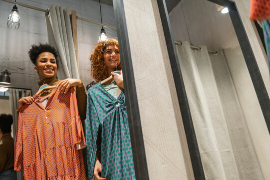 Multiracial women trying on clothes at fitting room