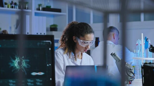 Cosmetology laboratory workers conducting experiment with organic plant extracts