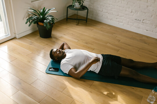 Male lying on yoga mat indoors