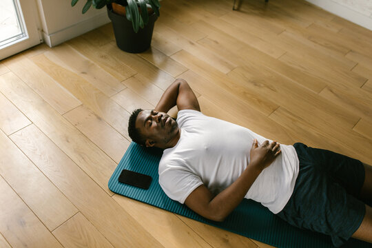 Man catching breath after exercising indoors