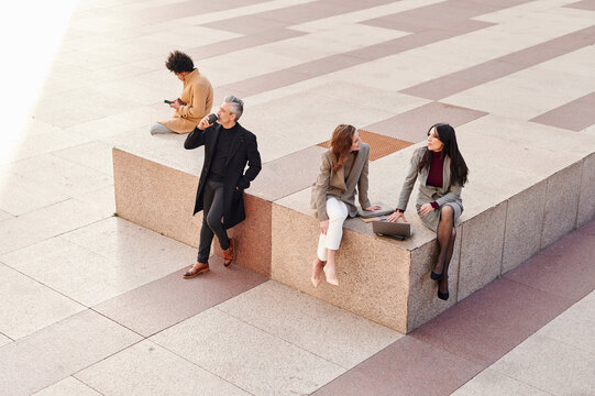 Businesspeople sitting in a city square during a break