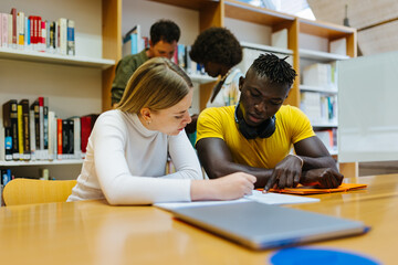 University students doing homework in the library