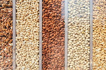 Walnuts, cashews, pistachios and almonds under shop window glass