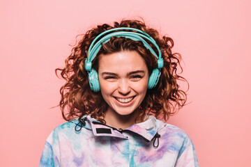 Happy redhead girl with headphones smiling at camera