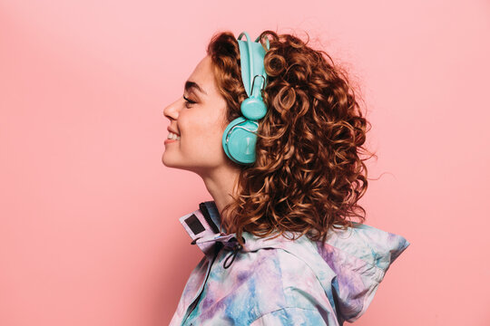 Happy redhead girl with headphones smiling at camera