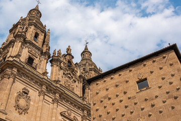 Vista de la fachada exterior de la casa de las conchas y de la iglesia barroca de La Clerecía en la ciudad de Salamanca, España