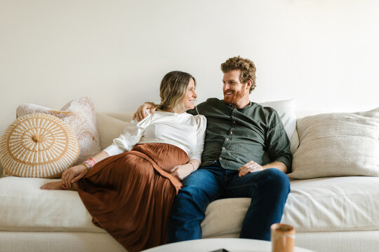 Middle age happy couple sitting on the living room sofa