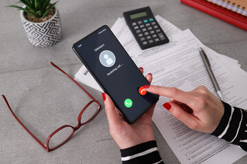 Unknown caller. A woman holds a phone in his hand and thinks to end the call. Incoming from an...