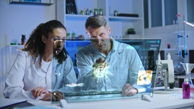 Lab scientist and assistant studying virus cell hologram, vaccine development