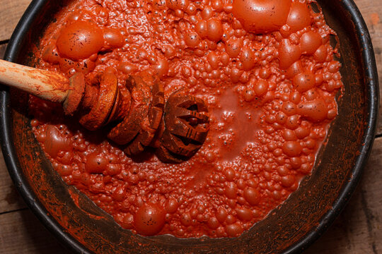 Black clay pot with a traditional red Mexican drink with foam 