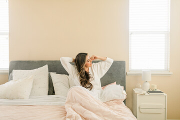 Relaxed woman in bed at luminous bedroom