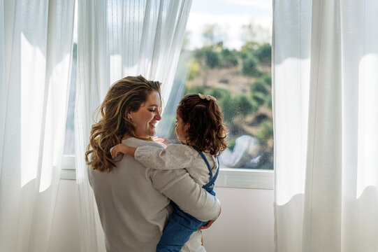 Mother with girl near window