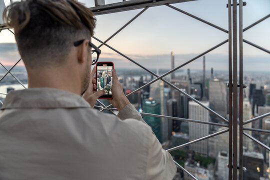 Guy is admiring Manhattan's panorama from high viewpoint