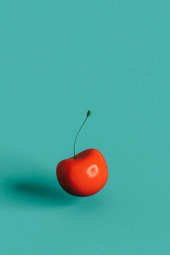 red cherries on a blue background with copy space