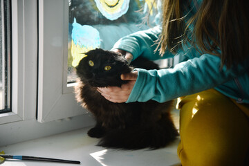 A girl sits on a windowsill