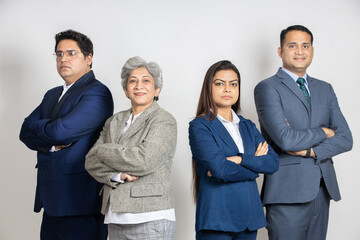 Group of positive indian business partners wearing suit standing cross arms looking at camera with...