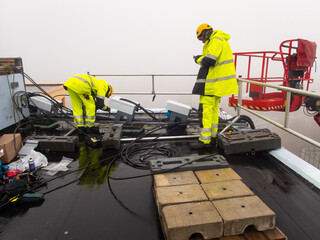 5G network installation, technicians work on a building using the lift