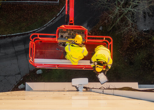 5G network maintenance, technicians work on a building using the lift
