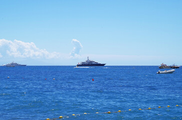 Luxury motor yachts anchoring at sea ashore of Positano, Amalfi Coast for deluxe summer Med vacation