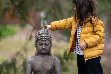 Child outside with buddha statue