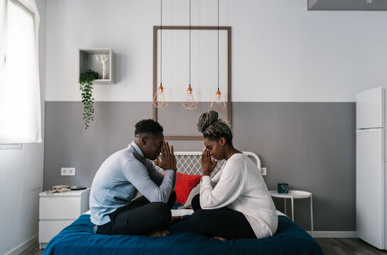 Couple praying on bed