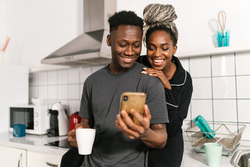 Content couple browsing smartphone in kitchen