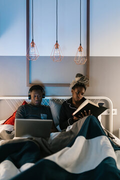 Couple ignoring each other in bed at night