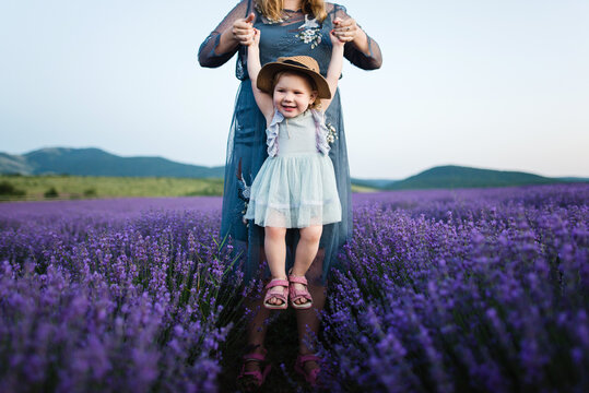 Mom playing with daughter in blooming lavender field