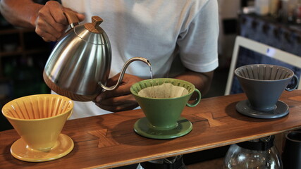 barista is making coffee at the shop.