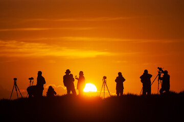A group of photographers capture sunrise. 