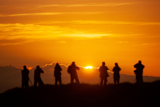 A group of photographers capture sunrise. 