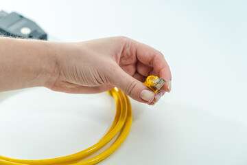 Close up of yellow RJ-45 cable on hand. Isolated