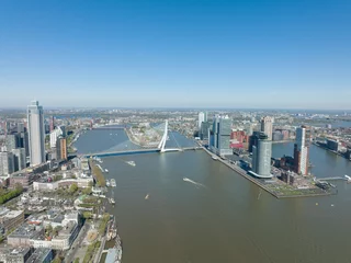 Papier Peint photo autocollant Pont Érasme Toits de la ville de Rotterdam aux Pays-Bas vue par drone sur la Meuse et les immeubles de bureaux vue sur la ville. Destination en Hollande. Erasmusbrug et vue sur la ville urbaine de la Meuse.
