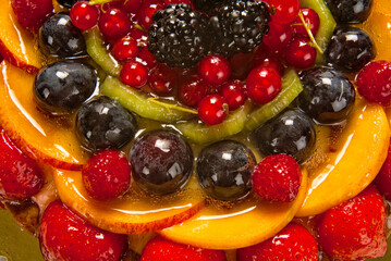 fruit tart with strawberries, blackberries, blueberries, peach slices and berries, detail from above