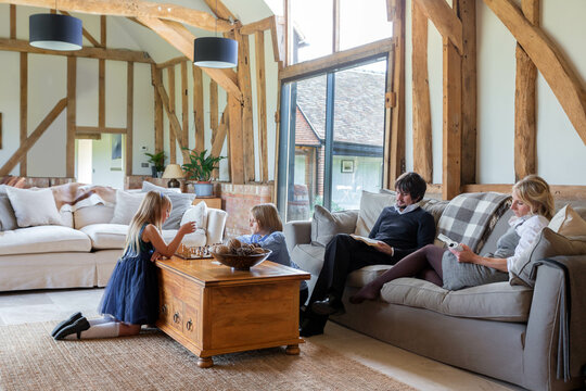Family relaxing in the luxurious family room of a renovated barn.