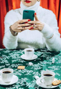 Female using mobile phone on coffee table.