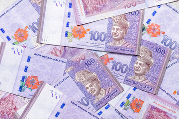scattered Malaysian money banknotes of one hundred ringgit, Business economic background