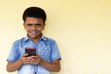 Dwarf man of Indian origin using mobile phone