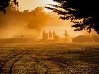 An anonymous group of golfers on a misty morning