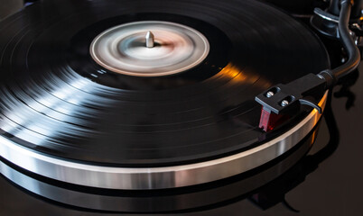 Moving vinyl player with red needle head. Retro and modern fusion. Vintage music player (selective focus)