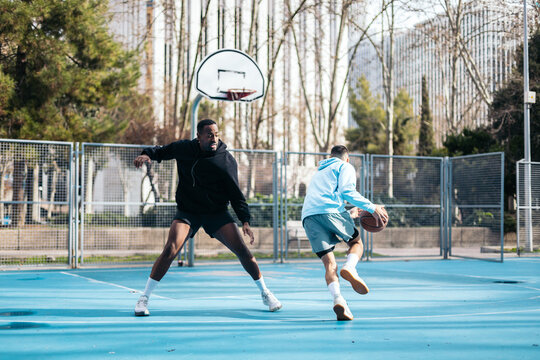 Young men playing basketball on an urban basketball court