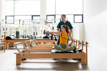Women's team doing exercises on pilates machine