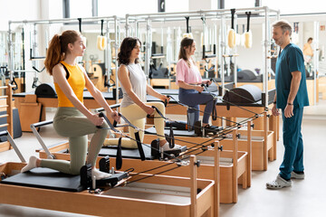 Women's team doing exercises on pilates machine