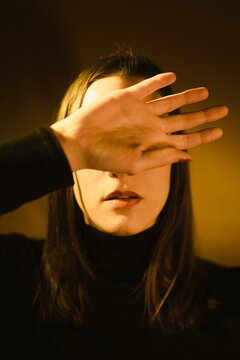 Woman covering her face with one hand with a sense of fear