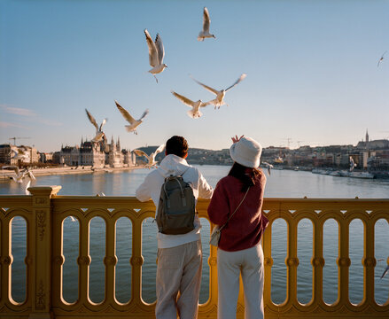 Couple on the bridge feeding seagulls