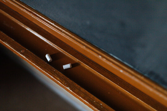 Two pieces of chalk sit broken on a blackboard