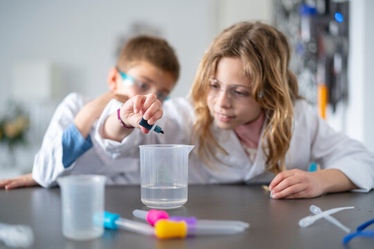 Children mixing chemical substances during lesson