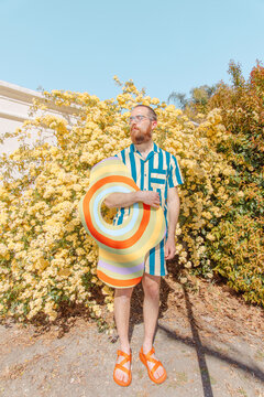 Man sunbathes in front of yellow flowers