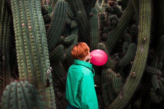 Inflating a balloon surrounded by cactus