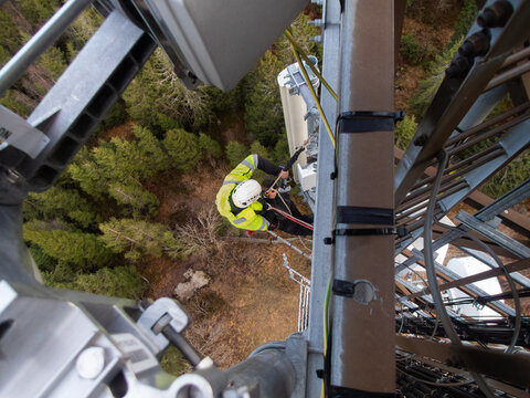 5G fiber optic technician on a telecommunication tower, hights working